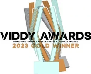 Graphic of an abstract trophy with the text "VIDDY AWARDS 2023 GOLD WINNER" for video excellence.