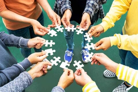 A group of peoples holding a puzzle pieces