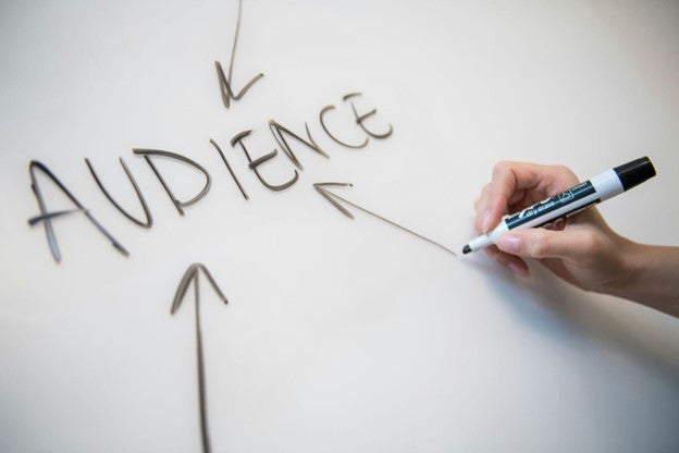 a person writing on a board using marker