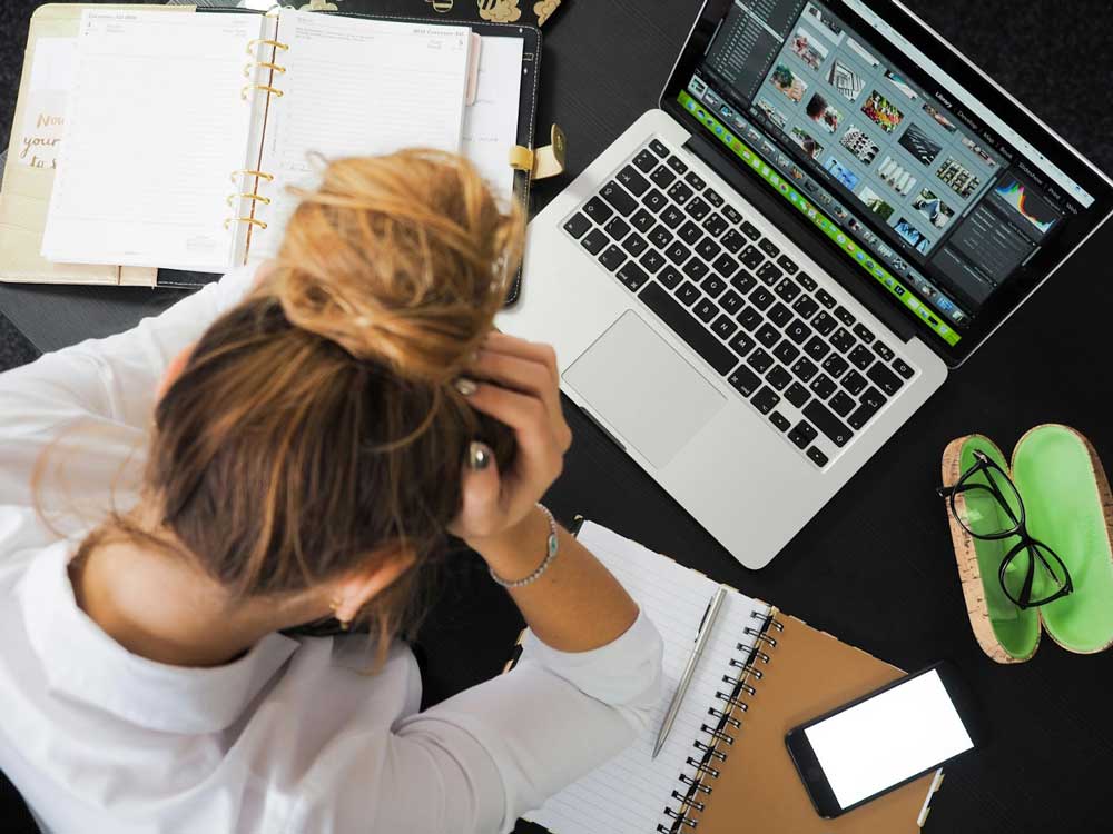 Women working on laptop holding head