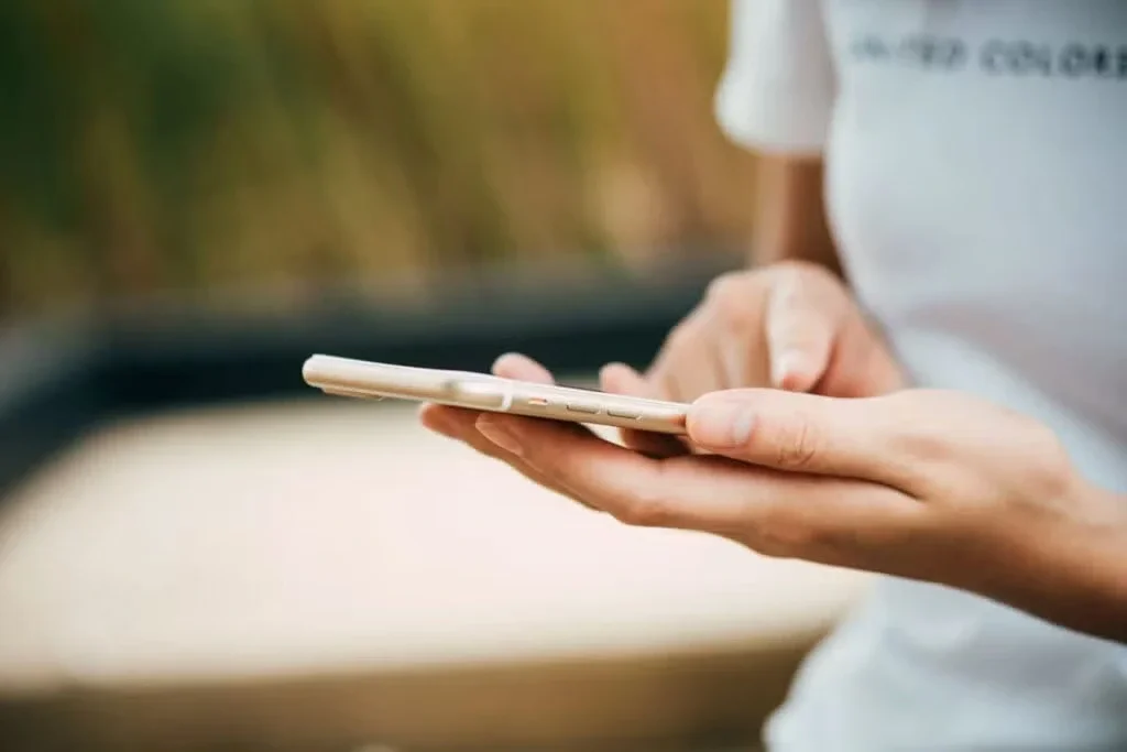 Person holding and using a smartphone with both hands.